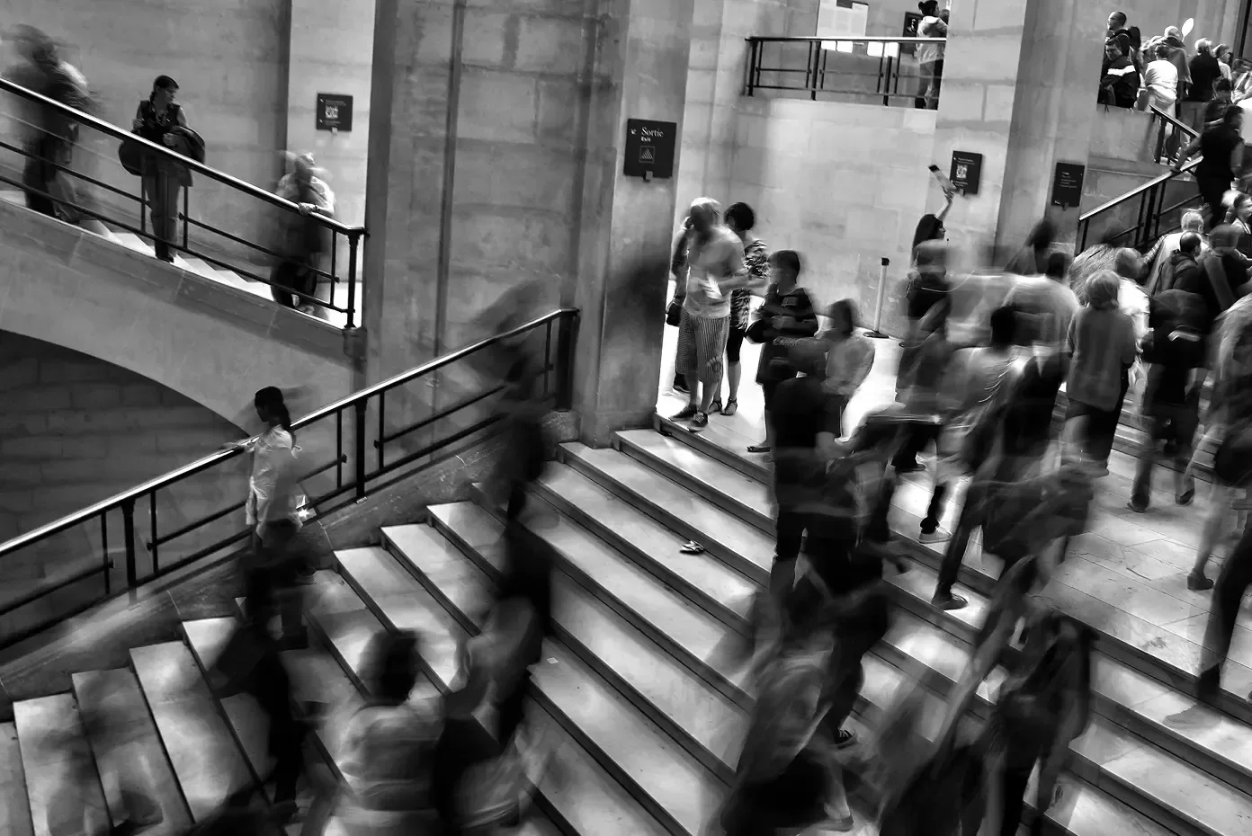 Blurred crowd of people moving up and down a stone staircase, illustrating strategy that is accessible to everyone